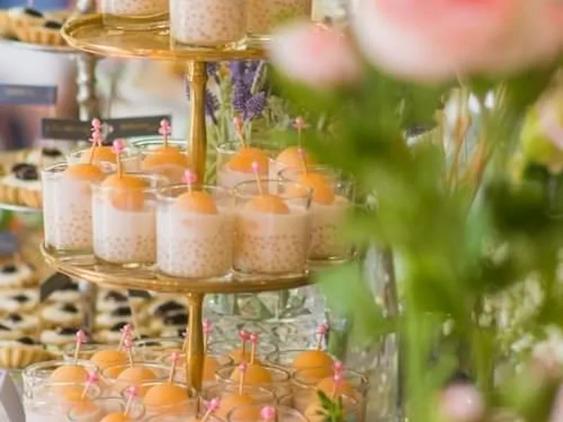 Detailaufnahme eines eingedeckten Catering-Tisches mit Blumen und Stoffservietten