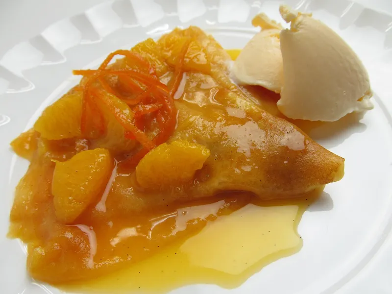 Flambierte Crêpe Suzette mit Orangenfilets und Vanilleeis