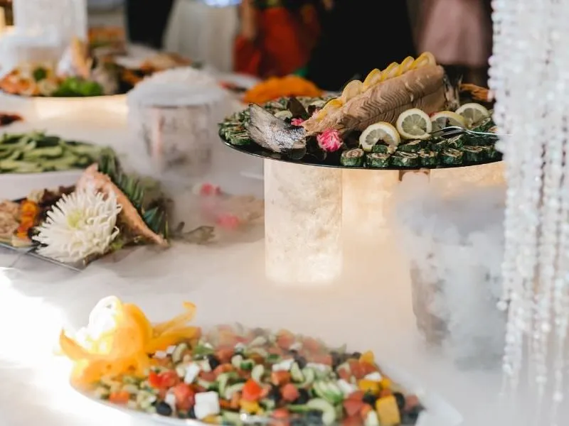 Elegant eingedeckter Hochzeitscatering-Tisch mit Rosen und Kerzenlicht