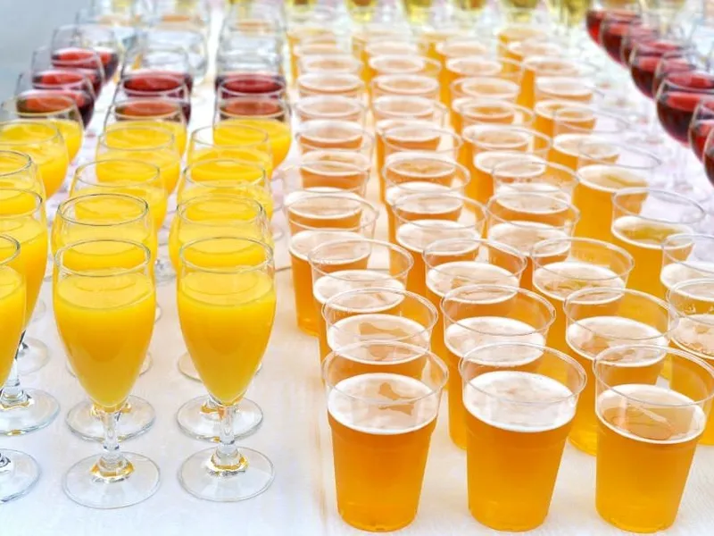 Reihe eleganter Gläser auf einer Catering-Bar, Sekt wird eingeschenkt